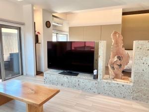 uma sala de estar com uma grande televisão de ecrã plano em Smart Stay Ito 201 em Ito