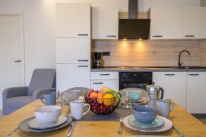 a wooden table with a bowl of fruit on it at Apartments & Rooms Darrer in Poreč