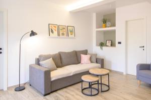 a living room with a couch and two chairs at Apartments & Rooms Darrer in Poreč