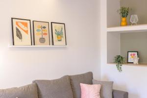 a living room with a gray couch and pictures on the wall at Apartments & Rooms Darrer in Poreč
