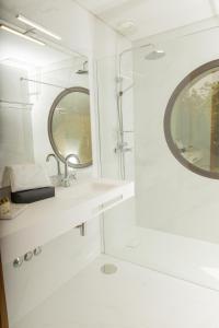 ein weißes Badezimmer mit einem Waschbecken und einem Spiegel in der Unterkunft QUINTA ALTO DO RIO in Cinfães