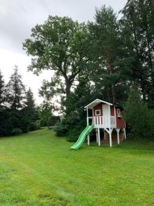 een speelhuis met een glijbaan in een tuin bij log cabin in Czech-Saxon Switzerland in Šluknov