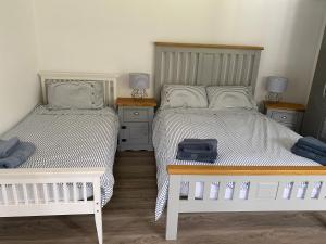 a bedroom with two beds and two night stands at Barn conversion in Perranwell