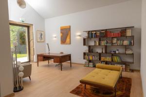 a living room with a book shelf and a desk at QUINTA ALTO DO RIO in Cinfães