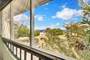a window with a view of the beach at Sand Dollar 1 Bedroom Oceanfront Apartment A16 in Kralendijk