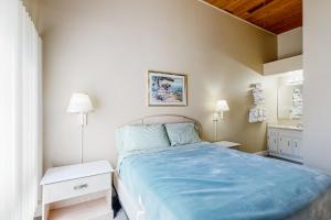 a small bedroom with a blue bed and two lamps at Borderlinks 10 in Ocean Pines