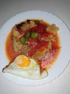 une assiette de nourriture avec un œuf et un pois dans l'établissement Habitacion de la marquesa, à Alcoleja
