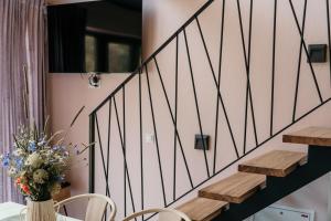 a staircase in a house with a table and chairs at Domek Discovery Mazury in Mrągowo
