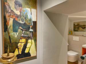 een schilderij van een man op een kruk in een badkamer bij L'Art de la fugue in Daverdisse