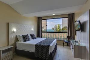 a hotel room with a bed and a balcony at Flat Pietra in Florianópolis