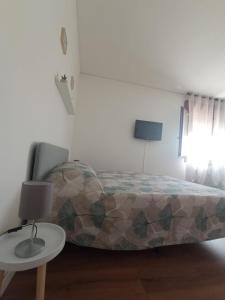 ein Schlafzimmer mit einem Bett und einem Tisch mit einer Lampe in der Unterkunft Casa Muci in Breda di Piave