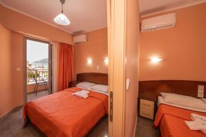 a bedroom with two beds and a balcony at Kalias Hotel in Vasiliki