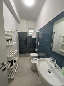 een badkamer met 2 toiletten, een wastafel en een douche bij IONIO Apartment in Porto Cesareo