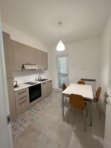 een keuken met een tafel en stoelen in een kamer bij IONIO Apartment in Porto Cesareo