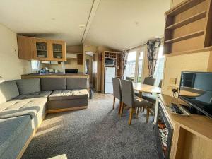 ein Wohnzimmer mit einem Sofa und einem Tisch sowie eine Küche in der Unterkunft Lovely 8 Berth Caravan Nearby Scratby Beach In Norfolk Ref 50021f in Great Yarmouth