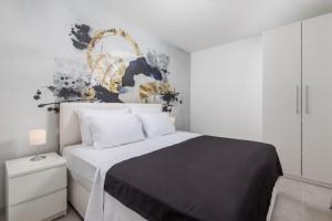 a bedroom with a bed with a black and white comforter at VILLA MAR - LUXURY APARTMENTS with pool and Deluxe apartment with hot tub in Selce, 20 meters from the beach in Selce +111 photos
