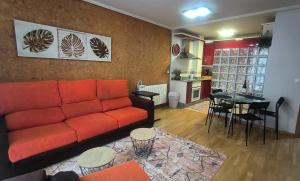 - un salon avec un canapé rouge et une table dans l'établissement El Arca, à Ponferrada