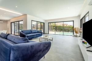 uma sala de estar com um sofá azul e uma televisão em Villa Vogue by Indigo em Estômbar
