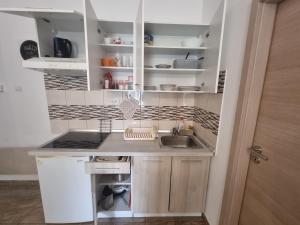 uma pequena cozinha com armários brancos e um lavatório em Studio Fiume-Potok em Rijeka