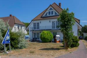 ein Haus mit einem Schild davor in der Unterkunft Ferienwohnung Wiek - Haus Meeresblick in Wiek auf Rügen 