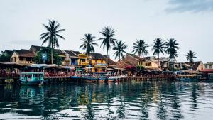 ホイアンにあるThe Linh Hoi An Villaの椰子の木や船が並ぶ水