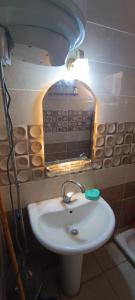ein Badezimmer mit einem weißen Waschbecken und einem Spiegel in der Unterkunft شاليه فندقى للعائلات غرفة وريسيبشن بمنتجع ريتال فيو الساحل الشمالى in El-Alamein