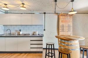 une cuisine avec des placards blancs et un bar avec des tabourets dans l'établissement Casa Luciana, TerreMarine, Trekking and Nature, à La Spezia