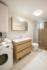 une salle de bain avec un lavabo et une machine à laver dans l'établissement Corfu Luxury Lofts by Corfuescapes, à Corfou
