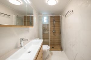 une salle de bain avec un lavabo, des toilettes et une douche dans l'établissement Corfu Luxury Lofts by Corfuescapes, à Corfou