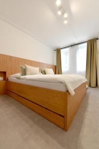 1 dormitorio con 1 cama grande de madera en una habitación en Apartmán Sihoť, en Trenčín