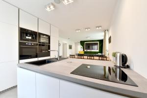 a kitchen with white cabinets and a stove top oven at Apartmán Sihoť in Trenčín
