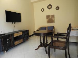 a living room with a table and a tv at Jogoo rooms in Dar es Salaam