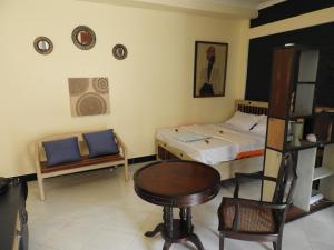 a bedroom with a bed and a table and a chair at Jogoo rooms in Dar es Salaam