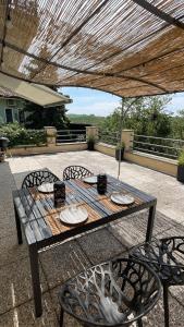 einen Holztisch und Stühle auf einer Terrasse in der Unterkunft Casa da Bertu in Barbaresco