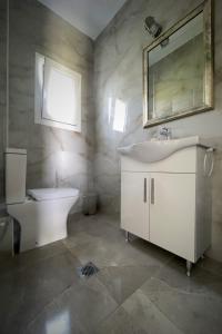 W łazience znajduje się umywalka, toaleta i lustro. w obiekcie Zeusplace Pool Villa Olympus Riviera w mieście Litochoro