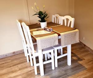 a white dining room table with white chairs and a plant at PUIGPEDROS15 in Puigcerdà