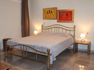 a bedroom with a bed with two tables and two pictures at Zeusplace Pool Villa Olympus Riviera in Litochoro