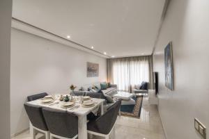 sala de estar con mesa con sillas y sofá en New Sea Front Apartment 135mq with Unlimited Wi-Fi, en Agadir