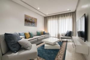 a living room with a couch and a table at New Luxury Apartment 135sqm Terrace Seafront Unlimited Wi-Fi in Agadir