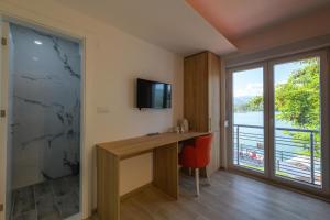 Habitación con escritorio, TV y ventana. en Lakeside Luxury Apartments, en Jablanica