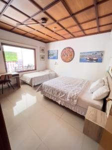 1 dormitorio con 2 camas, escritorio y ventana en ApartHotel Maison Suisse, en Asunción