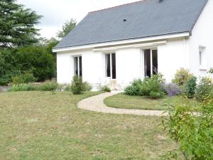 een wit huis met een loopbrug voor een tuin bij Clos Fleuri : Amboise Home with Amazing Gardens in Amboise