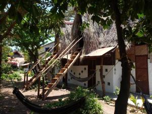 a hammock in front of a house with a tree at Maria Mulata Palomino in Palomino