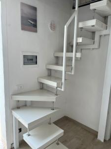 a staircase with white shelves in a room at Borghetto Mediterraneo in Santa Maria del Focallo