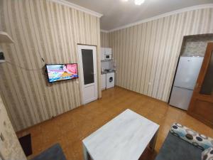 a living room with a refrigerator and a tv at Like Home Guesthouse in Yerevan