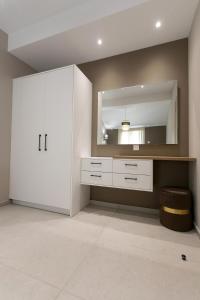 a bathroom with a white cabinet and a mirror at Mary‘s Apartments in Mesopótamon