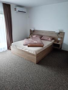 Un dormitorio con una cama con almohadas rosas. en king, en Băile Felix