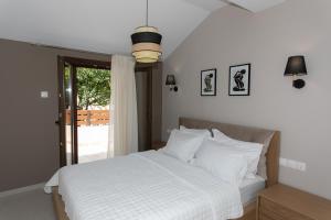 a bedroom with a bed with white sheets and a window at Mary‘s Apartments in Mesopótamon