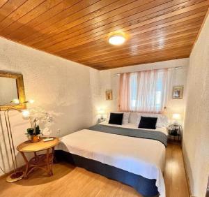 1 dormitorio con 1 cama grande y techo de madera en Seaside Lux, en Dugi Rat