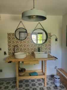 a bathroom with two sinks and two mirrors at So Home in Saint-Pantaléon-les-Vignes